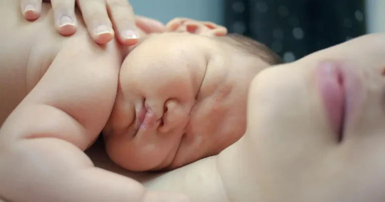 Newborn baby peacefully sleeping on a parent's chest, held close with a gentle hand resting on the baby – skin-to-skin bonding moment, Velcro Baby