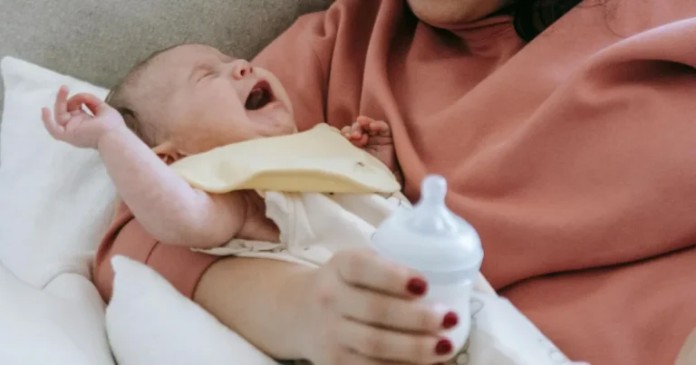 Infant crying in a woman's arms with a feeding bottle in hand, signs baby is too hot while sleeping