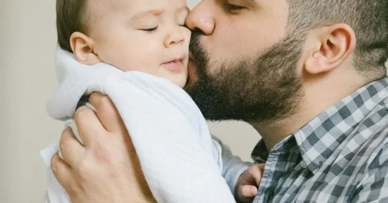 Father holding and kissing his little baby boy